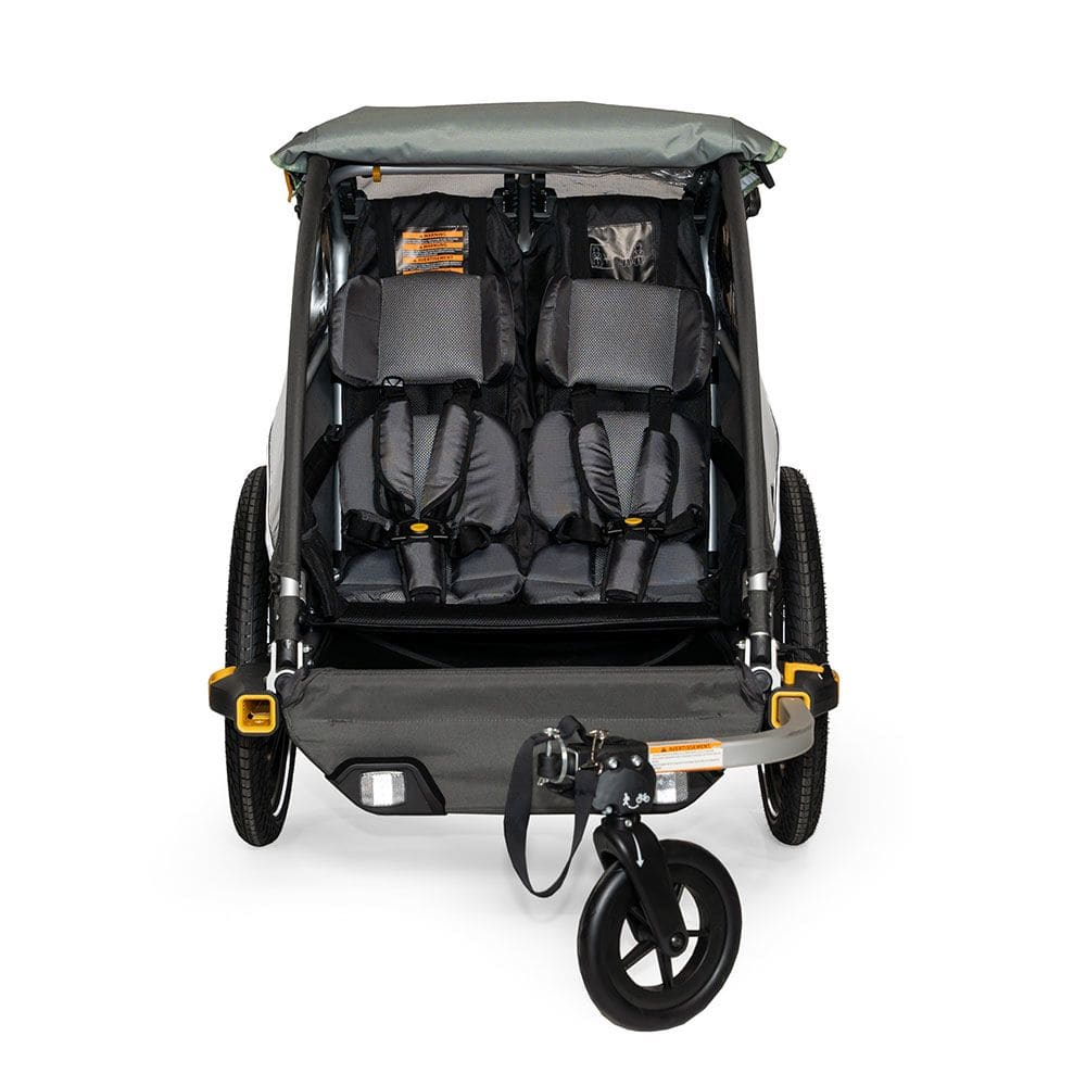 Burley D'Lite X double bike trailer and stroller with adjustable suspension, shown with safety harness and storage compartments.