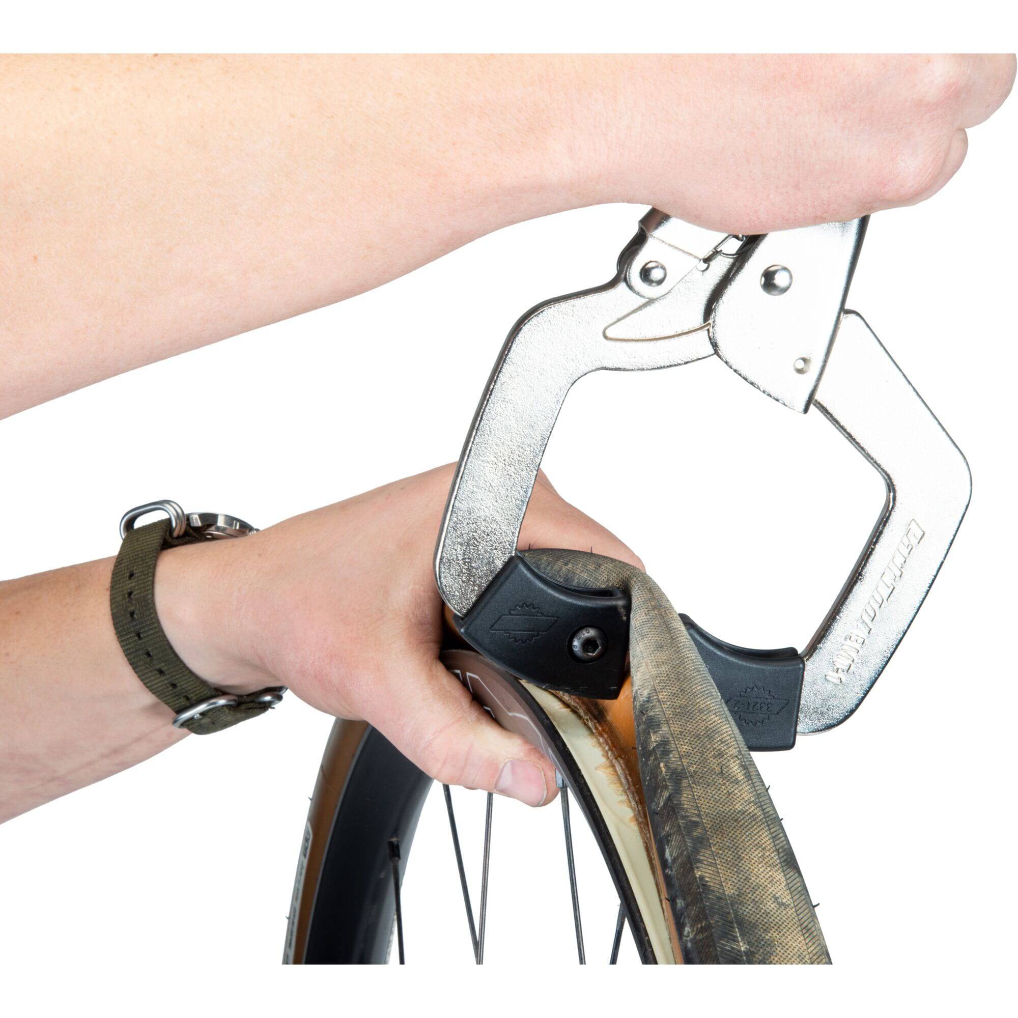 Park Tool BMT-1 bicycle tyre bead breaker for tubeless and tight-fit tires, shown in workshop setting with tools and bike components.