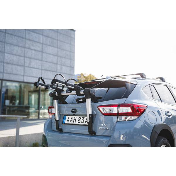 Thule OutWay rear-mount 2 bike carrier rack with anti-sway mechanism and locking cable attached to a vehicle for bike transportation.
