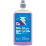 White Lightning Wet Ride Chain Lube applied on a bicycle chain, showcasing heavy-duty waterproof bike lubricant for wet conditions.