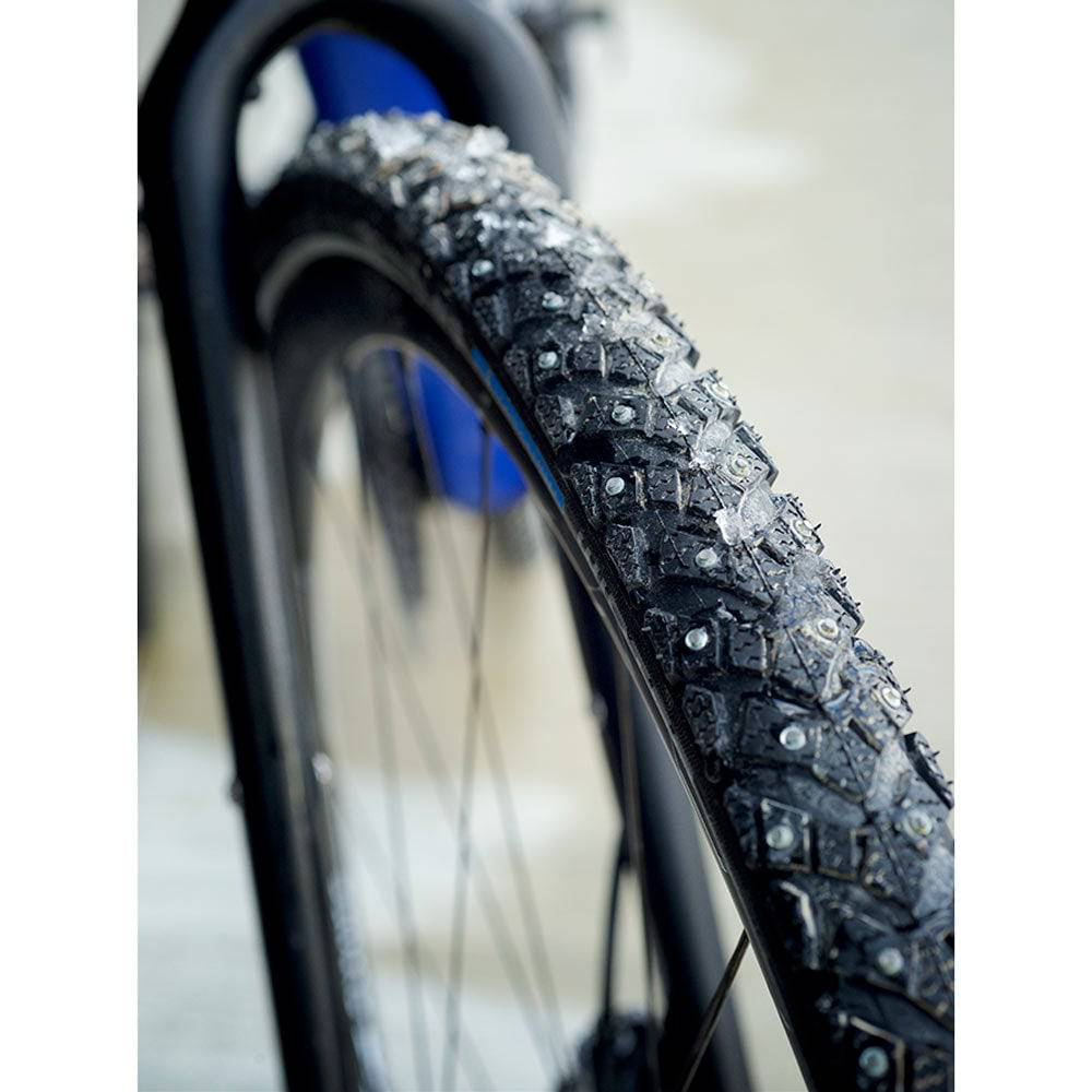Schwalbe Marathon Winter Raceguard tyre with 168 spikes for icy roads, showing tread pattern and spike placement.