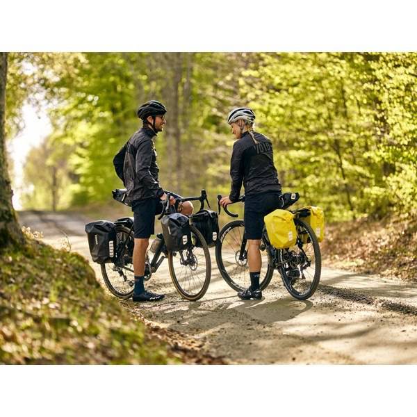 Thule Shield waterproof panniers with reflective panels and adjustable mounts, designed for bike storage and outdoor adventures.