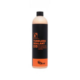 Orange Seal tubeless sealant refill for puncture protection in bike tires, showing the sealant container and bike tire setup.