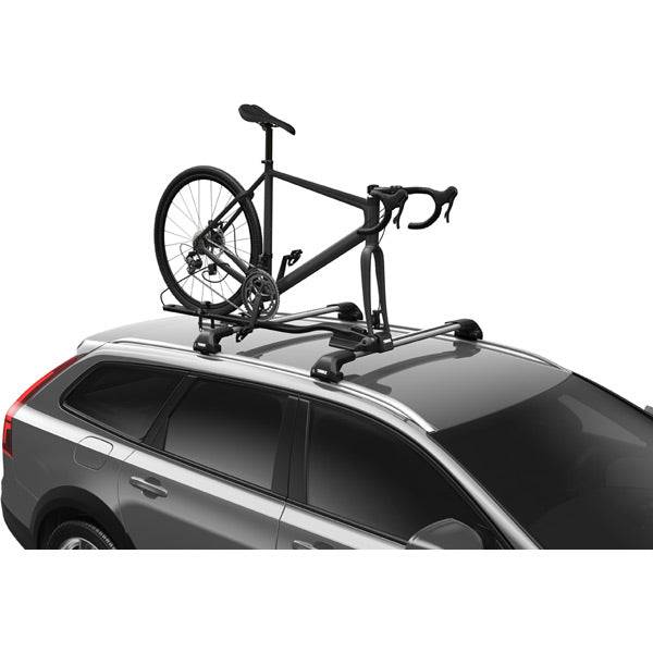 Thule 564 FastRide fork mount bike carrier attached to vehicle roof rack with a bike secured in front fork locking mechanism.