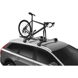 Thule 564 FastRide fork mount bike carrier attached to vehicle roof rack with a bike secured in front fork locking mechanism.
