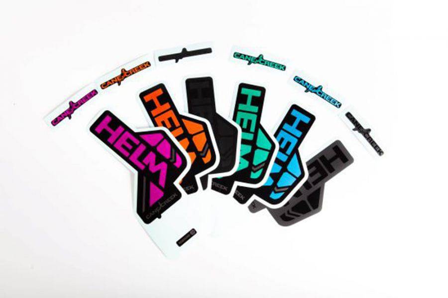 Cane Creek HELM fork sticker kit with spare decals for customization, featuring colorful labels and branding details.