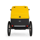 Burley Bee bike trailer for kids with 5-point harness, storage compartments, and safety features, designed for family cycling adventures.