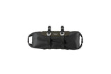 Brooks Scape handlebar roll bag in waterproof mud green for bikepacking, mounted on a bicycle handlebar.
