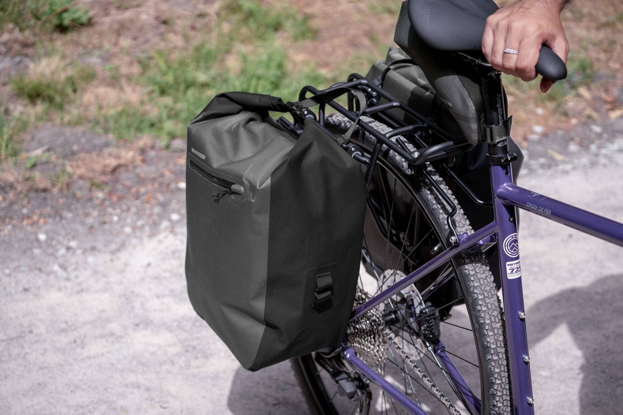 Madison Bags Roam 30L waterproof pannier bag with quick-release mounting system, shown attached to bicycle rack.