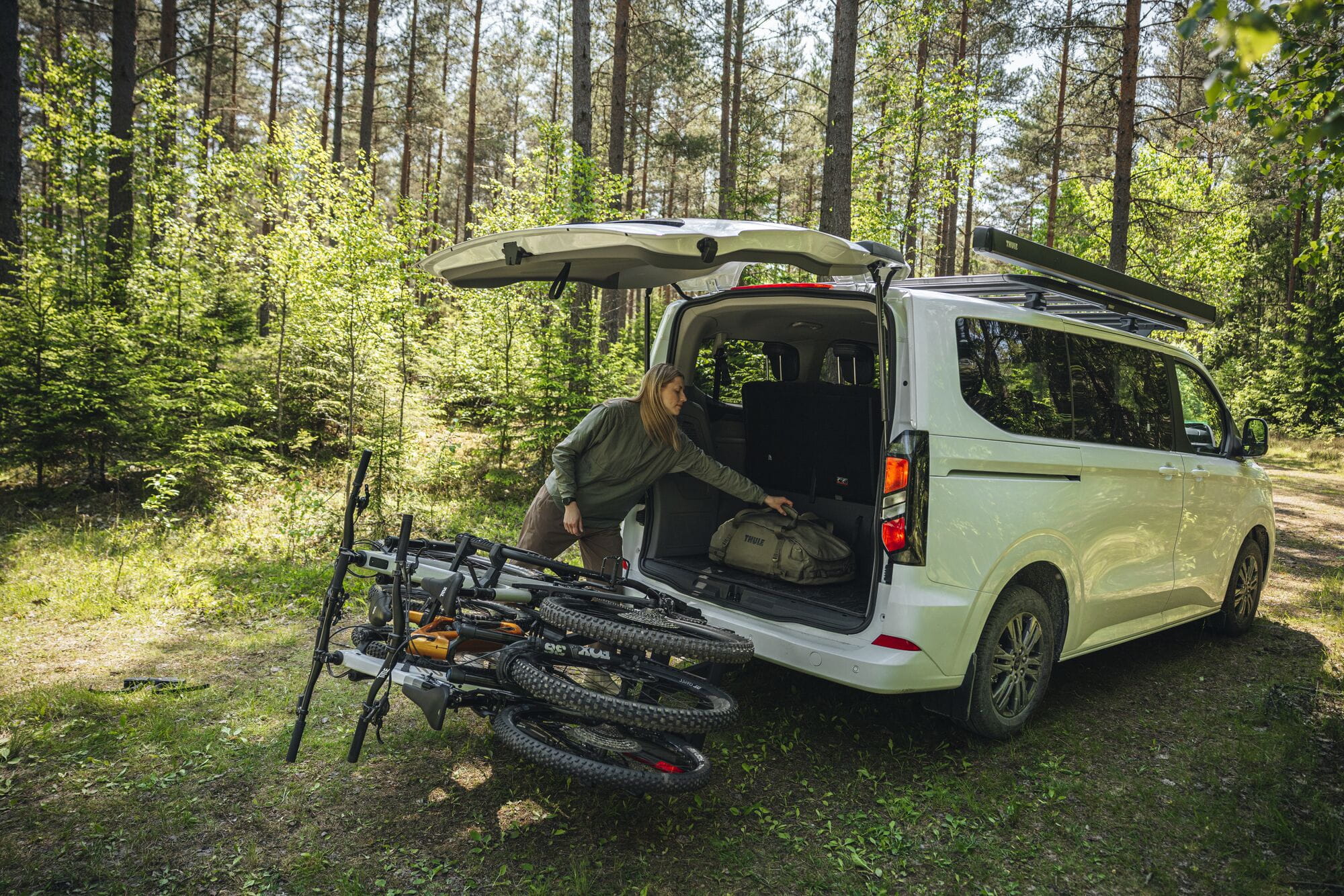 Thule VeloSpace 3-bike towball carrier with 13-pin connector, designed for e-bikes and mountain bikes, mounted on a vehicle.