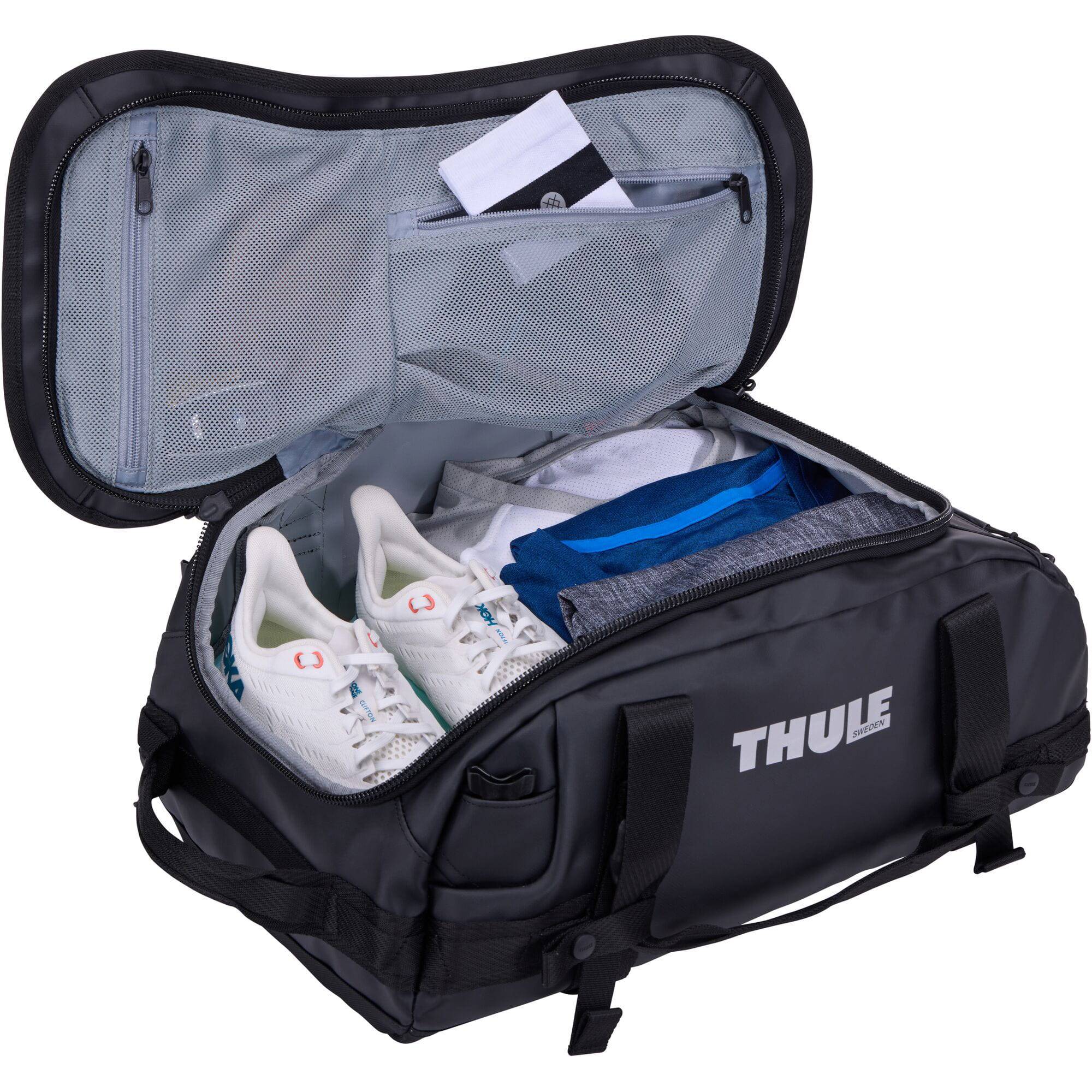 Thule Chasm recycled 30L duffel bag with convertible backpack straps, shown in black with side zipper pocket and durable design.