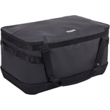 Thule Chasm Gear Hauler waterproof semi-rigid storage bag for travel and camping accessories, shown in a camping setting.