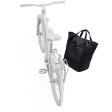 Thule Chasm Tote InLock 25L water-resistant tote bag with bike rack compatibility, featuring durable straps and secure zipper closure.
