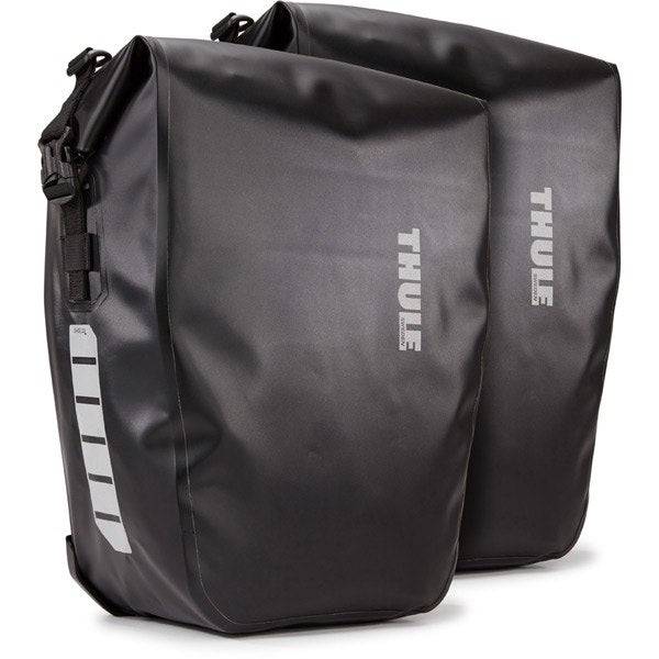 Thule Shield waterproof panniers with reflective panels and adjustable mounts for secure bike storage.