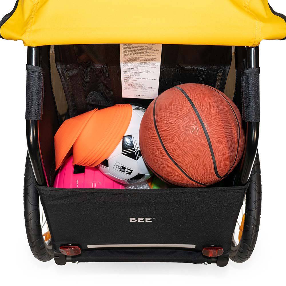 Burley Bee bike trailer for one child with safety harness and weather cover, outdoor accessories for safe cycling.