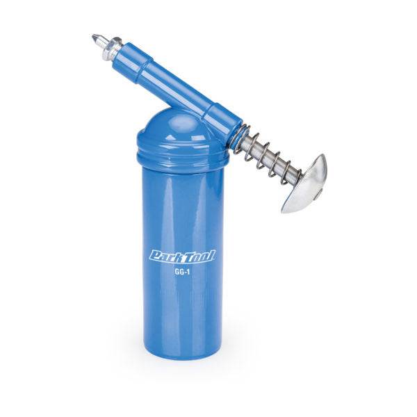 Park Tool GG-1 grease gun for precise lubrication, shown with workshop setup and compatible Park Tool compounds.