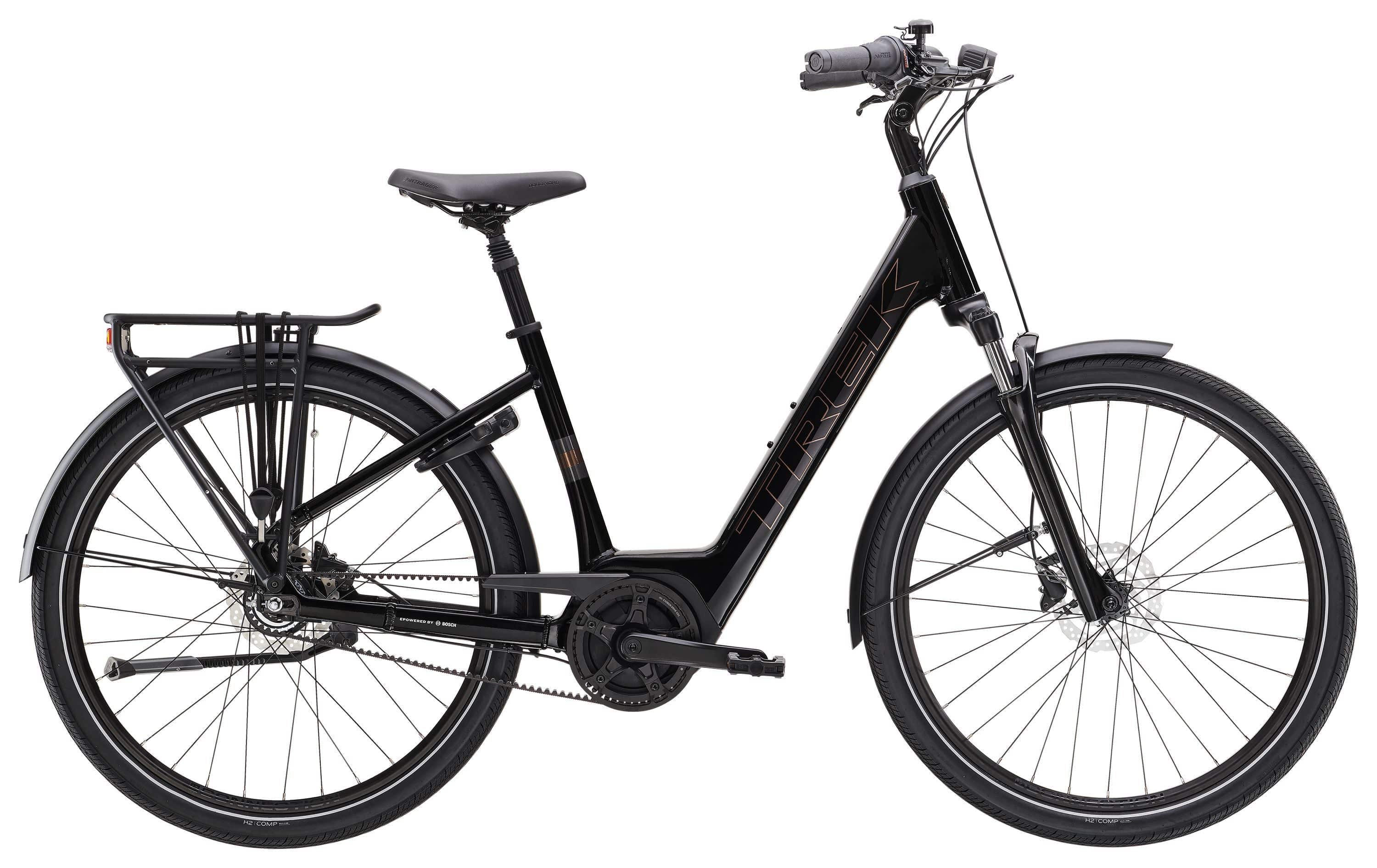 Trek District+ 2 Belt Lowstep Women's E-Hybrid Bike with sleek frame and urban commuting features, parked on city street.