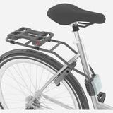 Urban Iki TA-KE rear child seat for e-bike, mounted on bike frame, with safety harness and comfortable padding for young riders.