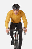 Rab VR Cinder Softshell Cycling Jacket in Sahara color, featuring Vapour-Rise™ technology for wind protection, worn by a cyclist.