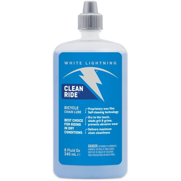 White Lightning Clean Ride dry wax chain lube applying to bicycle chain, self-cleaning bicycle lubricant for bike maintenance.
