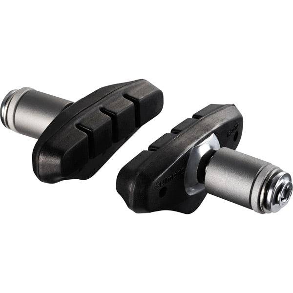 Shimano R50T2 BR-CX50 brake shoe pair with medium spacer and fixing bolts for bicycle brake system, shown with components and hardware.