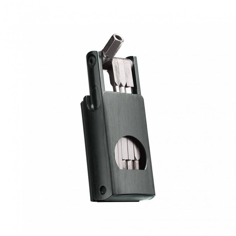 Crankbrothers F11 multi tool in black with tyre plug and chain link holder for bike maintenance, shown on workshop surface.