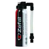 Zefal puncture repair spray for bikes, showing a workshop setting with the spray bottle and bike tire repair tools.