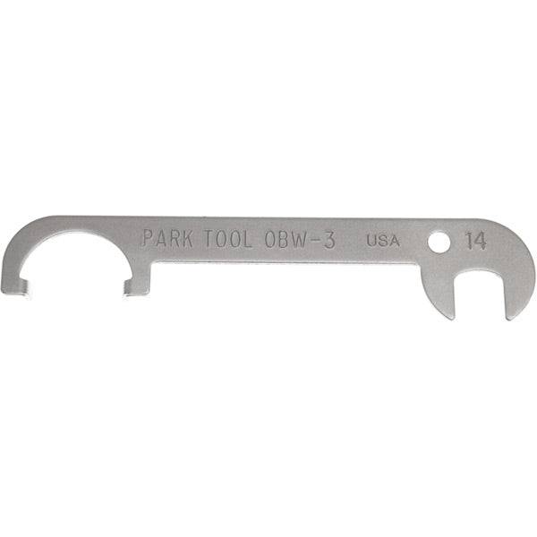 Park Tool OBW-3 offset brake centering tool with 14mm wrench for aligning caliper brakes in a workshop setting.