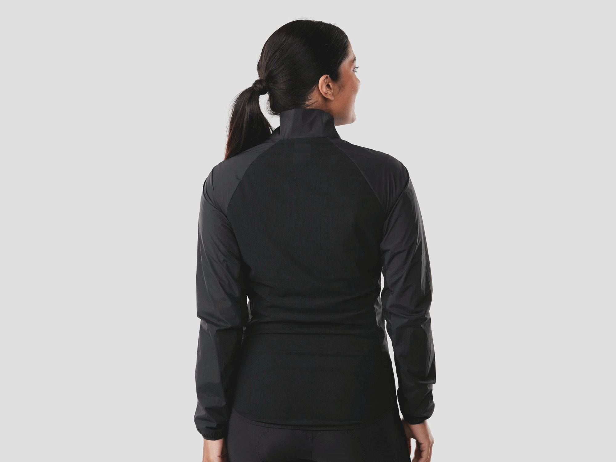 Trek Circuit Women's lightweight wind-resistant cycling jacket, packable windshell, shown in a natural outdoor setting.
