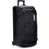 Black Thule Chasm rolling duffel bag with durable, weather-resistant fabric and sturdy wheels for travel accessories.