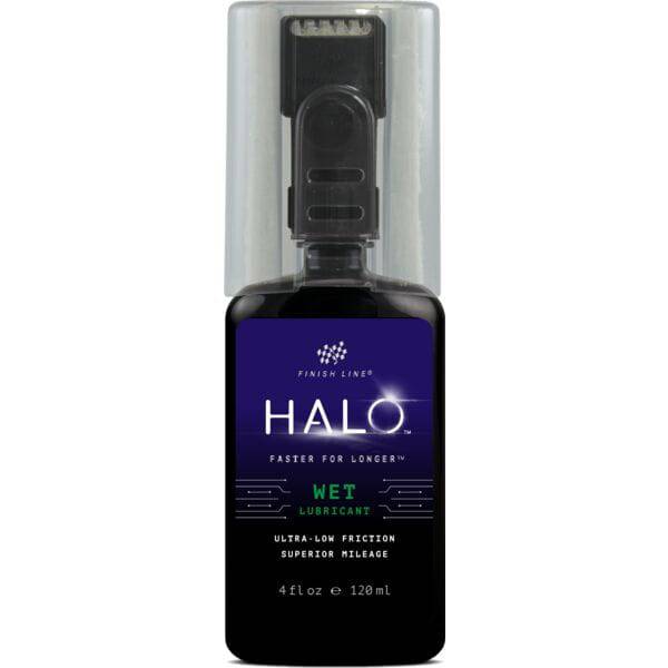 Finish Line Halo Wet Lubricant for bicycle chains, featuring Smart Luber™ technology, shown in a workshop setting.