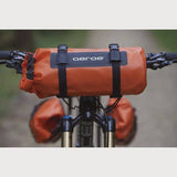 Aeroe 8L waterproof dry bag with quick release straps, designed for bike rack accessories, in black with adjustable closures.