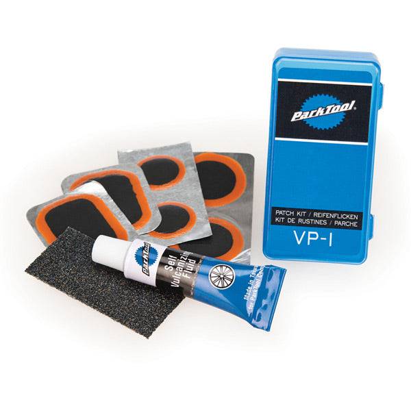 Park Tool VP-1 vulcanising patch kit for permanent inner tube repairs, shown with patches and repair tools on a workshop surface.