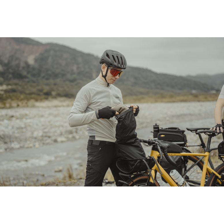 Topeak Rackloader Drybag 12L weatherproof bike rack bag with straps, shown attached to a bike rack for outdoor cycling.
