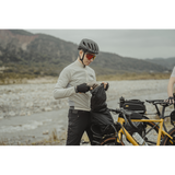 Topeak Rackloader Drybag 12L weatherproof bike rack bag with straps, shown attached to a bike rack for outdoor cycling.