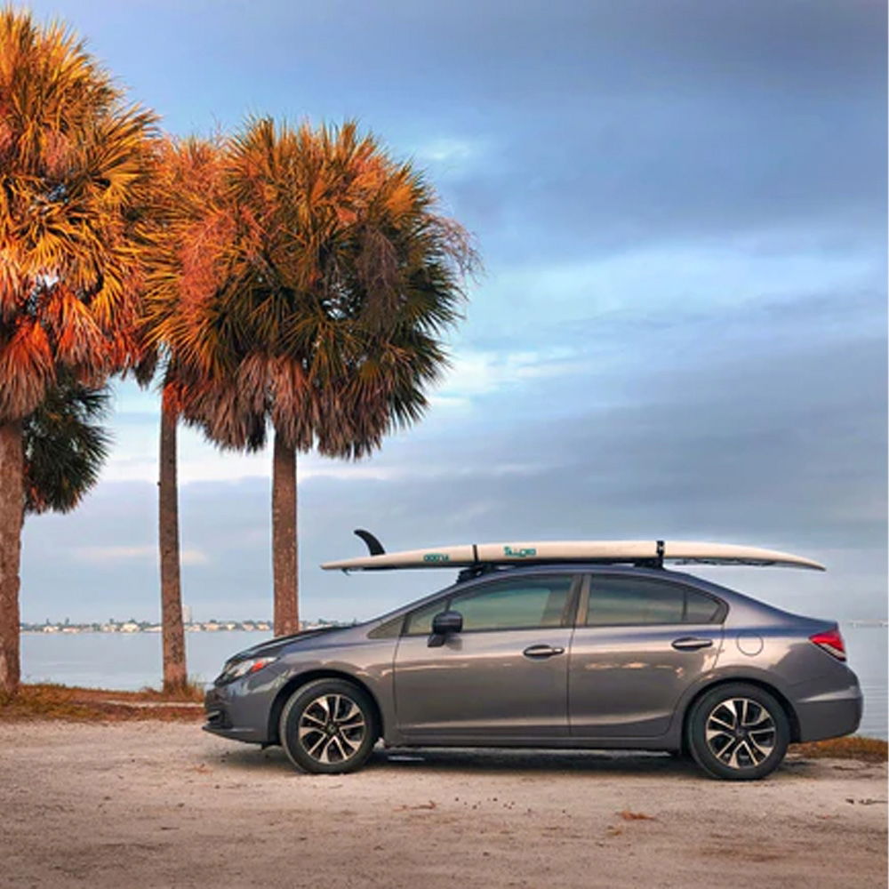SeaSucker Board Rack with vacuum mounts attached to car for surf and paddle boards, showcasing easy and secure transportation accessories.