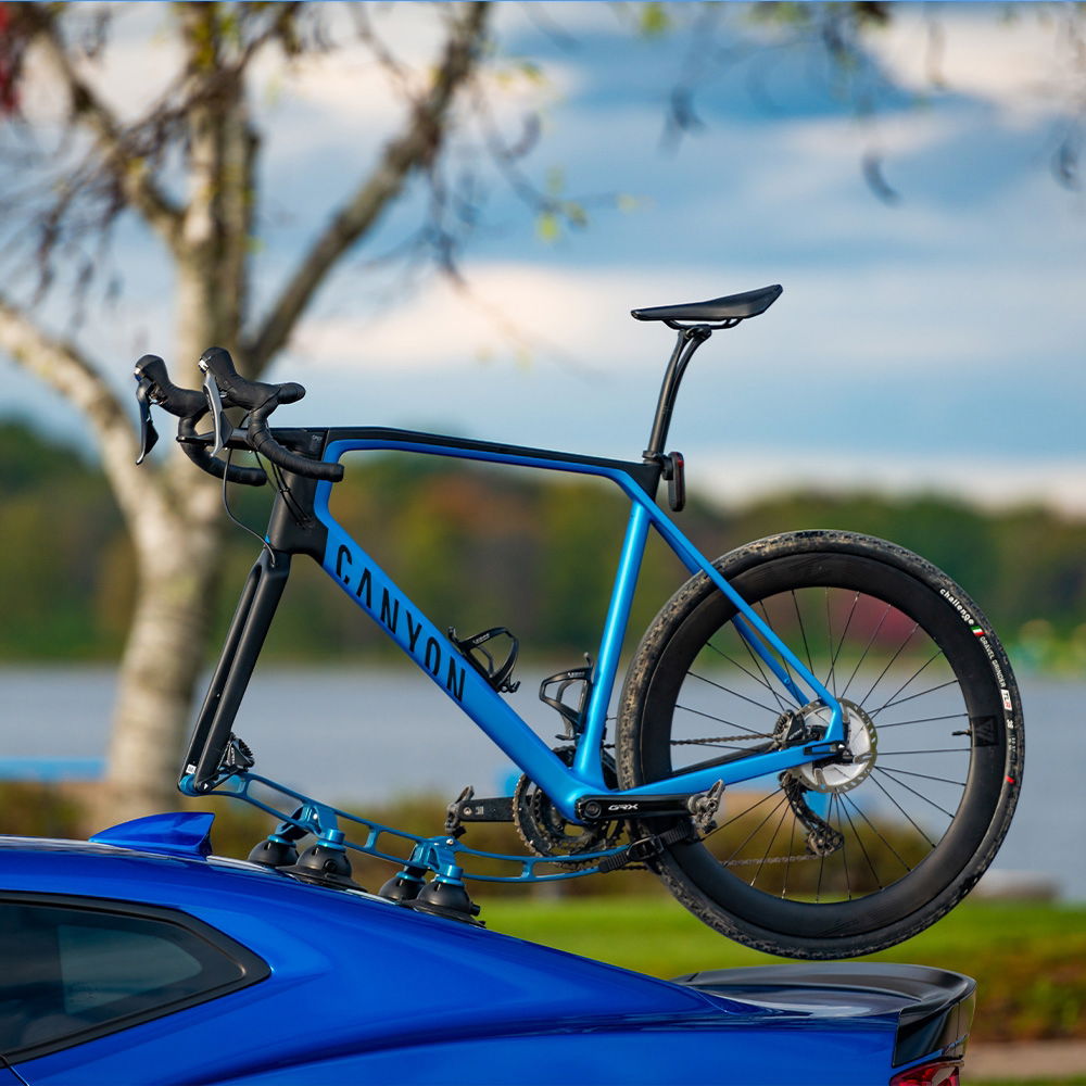 SeaSucker Komodo 1 Bike Rack for sports cars and convertibles, compact roof mount, shown attached to a blue convertible vehicle.