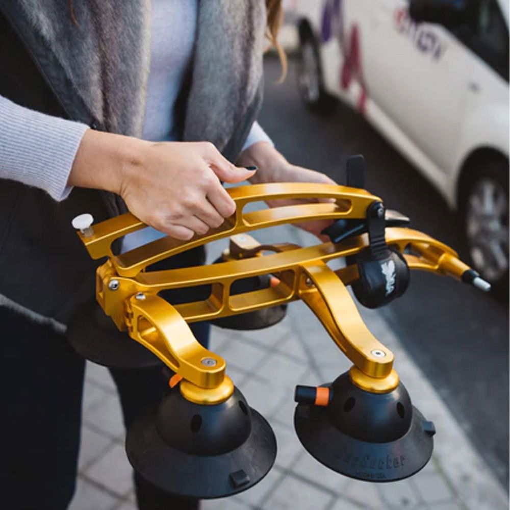 SeaSucker Komodo 1 Bike Rack for sports cars and convertibles mounted on a compact roof, showcasing its gold finish and sleek design.