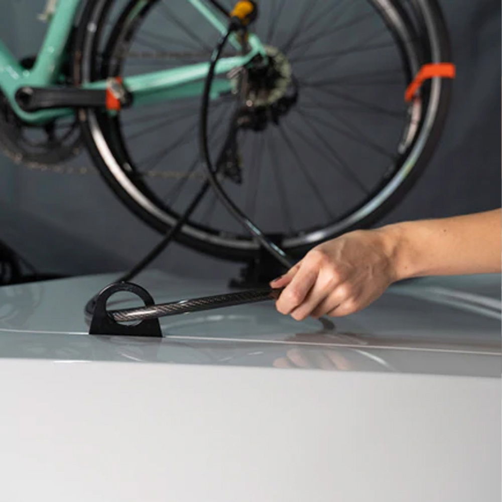 SeaSucker Cable Anchor Trunk securing a bike lock on a car trunk or hatchback in a lifestyle setting.