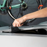 SeaSucker Cable Anchor Trunk securing bike lock on hatchback, showing installation on vehicle trunk for bicycle security accessories.
