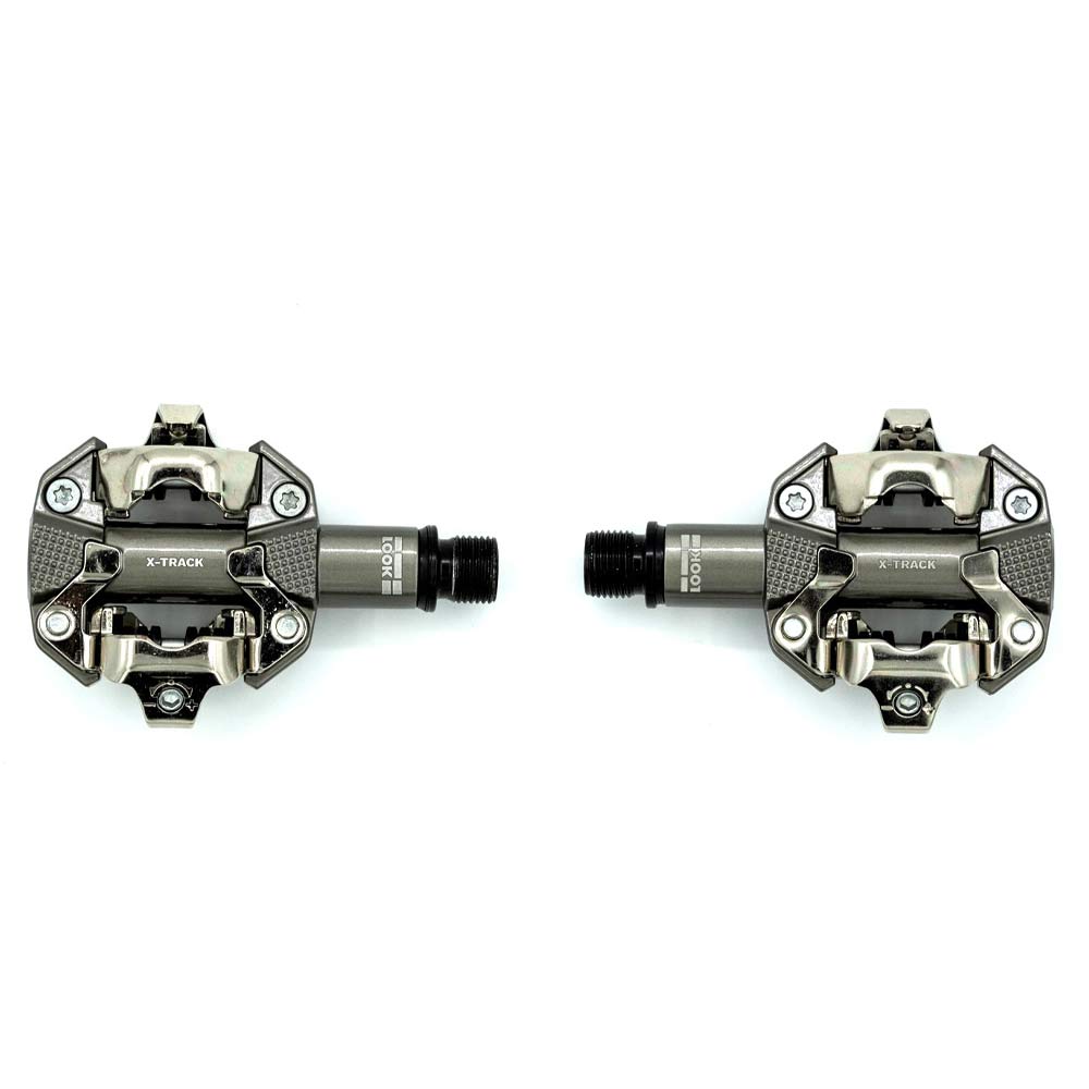 Look X-Track MTB pedals in metallic grey with SPD compatibility and adjustable tension, mounted on a bicycle crank.