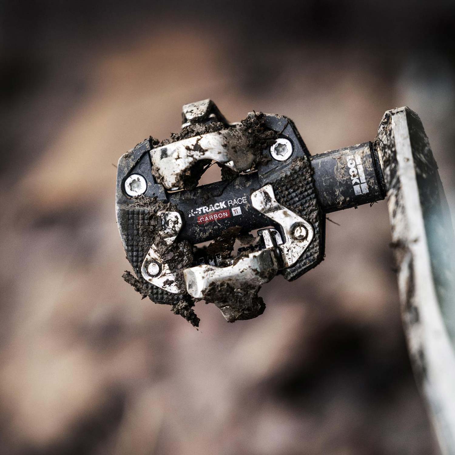 Look X-Track Race Carbon Ti MTB pedals with adjustable SPD cleat tension, featuring lightweight carbon and titanium construction.