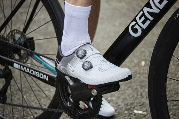 Madison Flux performance cycling socks with breathable mesh and compression support, shown on a cyclist's feet.