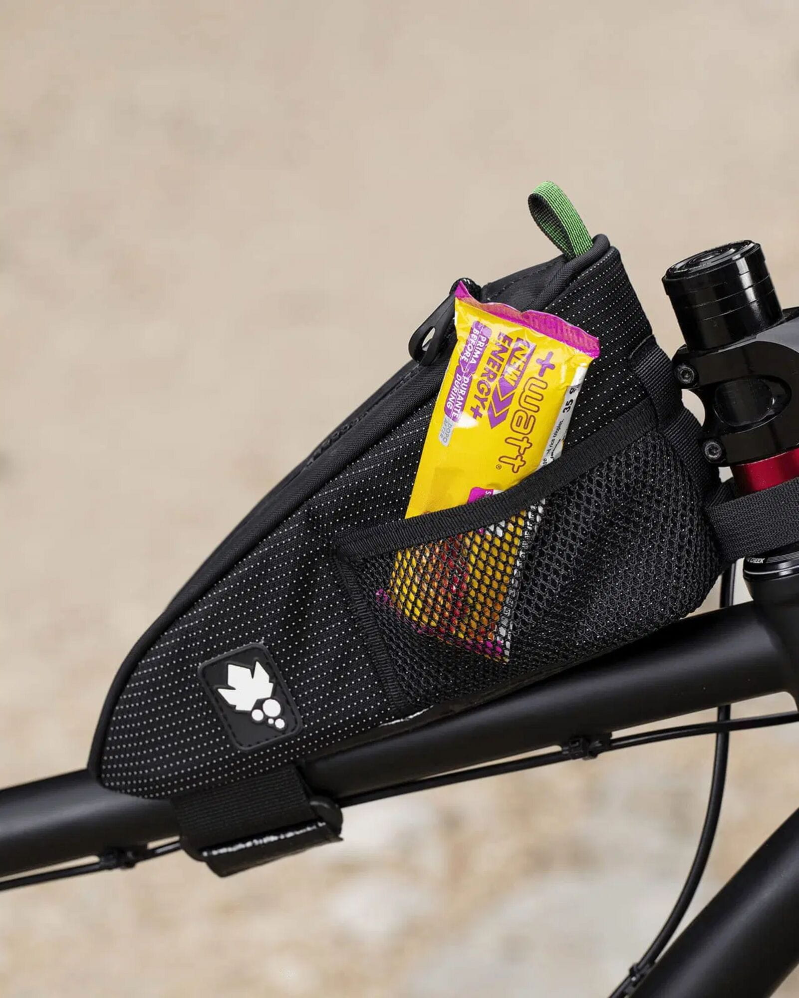 Miss Grape Node Adventure strap-mount top tube bag for cycling storage, shown attached to a bike frame in a scenic outdoor setting.