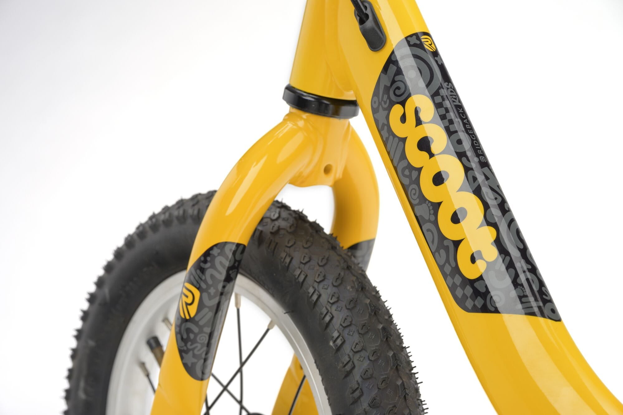 Yellow Ridgeback Scoot 2027 kids balance bike for toddlers age 2+ with a close-up of the bike's frame and handlebar details.